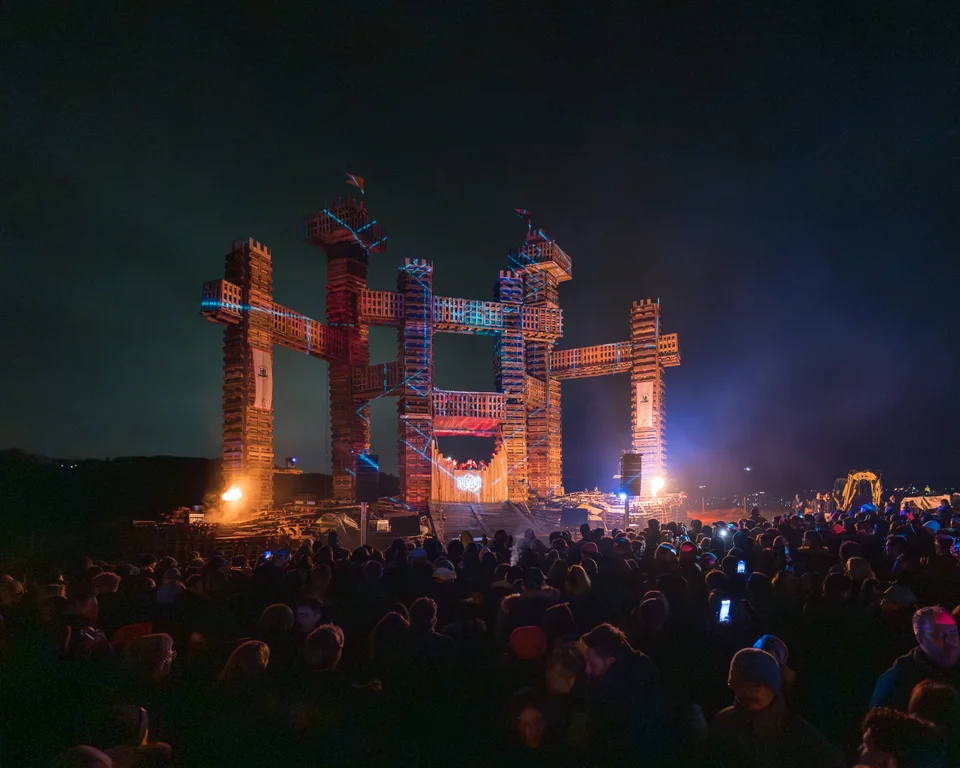 Monumental PEAK Fortress structure with crowd at night